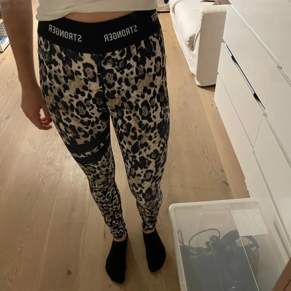 Snygga leopardmönstrade leggings från Stronger i bra skick. De är tighta och perfekta för träning eller en avslappnad dag. Elastisk midja med logotypen 'STRONGER' runtom. Materialet är mjukt och stretchigt för bästa komfort.. Jeans & Byxor.