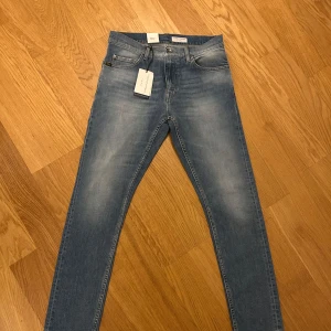 Ljusblå jeans från Tiger of Sweden - Säljer ett par snygga ljusblå jeans från Tiger of Sweden i modellen Pistolero, midwaist, mansmodell. Perfekt som julklapp☺️ Helt nya och oanvända med prislappen kvar! Nypris 1600!😍