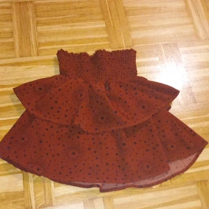 Röd kjol med stjärnmönster - Säljer en superfin röd kjol med svart stjärnmönster. Den har en elastisk midja som gör den bekväm och lätt att bära. Kjolen har en volangdetalj som ger extra stil och rörelse. Perfekt för både vardag och festliga tillfällen! 🌟