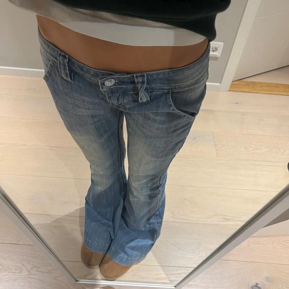 Säljer ett par snygga blå bootcut jeans i bra skick. De är lågmidjade och har en klassisk femficksdesign med knapp och dragkedja fram. Perfekta för en avslappnad vardagslook eller en utekväll. Passar bra med sneakers eller boots! Sjukt snygga och populära💗😋🥹✨Midjemått: ca 36 cm rakt över och innerbenslängd: ca 79cm🥹🥹💗☺️🧘‍♀️. Jeans & Byxor.