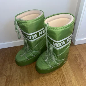 Gröna Moon Boots - Säljer ett par gröna Moon Boots i storlek 39-41 men passar mig med 37/38 bra också, dem är i mycket bra skick. De är perfekta för vintern med sin varma och vadderade insida. Skorna har en cool retrostil med snörning och en robust sula för bra grepp. Perfekta för att hålla fötterna varma och torra i snön! Bootsen är knappt använda. 