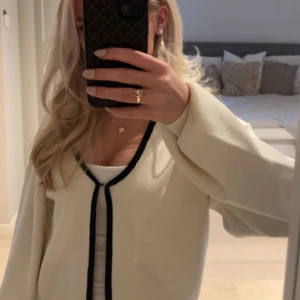 Vit kofta med svarta detaljer - Säljer en superfina koftan som är slutsåld i sortimentet. Den har tyvärr aldrig kommit till användning, men den är hur söt som helst och super mjukt material😍😍