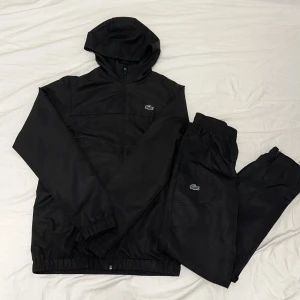 Lacoste Tracksuit  - Helt svart Lacoste Tracksuit använd 2-3 gånger max storlek Xs 10/10 skick, Pris 1599kr priset går att sänkas!