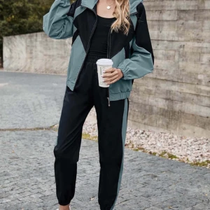 Grön och svart vindjacka - Säljer en snygg grön och svart vindjacka med dragkedja. Jackan har en cool design med kontrasterande färgblock och en bekväm passform. Perfekt för höstpromenader eller som en lätt jacka under våren. Den har långa ärmar och en elastisk nederkant för extra komfort. medföljer byxor också!