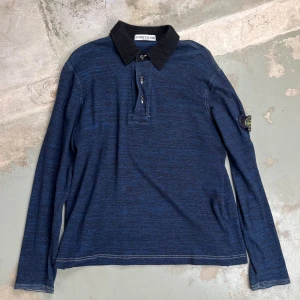 Stone Island - Longsleev Piké - Snygg mörkblå och långärmad piké med svart krage samt matchande svarta knappar.  Material 100% Bomull  *Storleken upplevs en aning mindre.