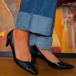 Svarta pumps från Peter Kaiser - Säljer ett par eleganta svarta pumps från Peter Kaiser. Skorna har en spetsig tå och är tillverkade i skinn, vilket ger dem en lyxig känsla. Perfekta för både fest och mer formella tillfällen.