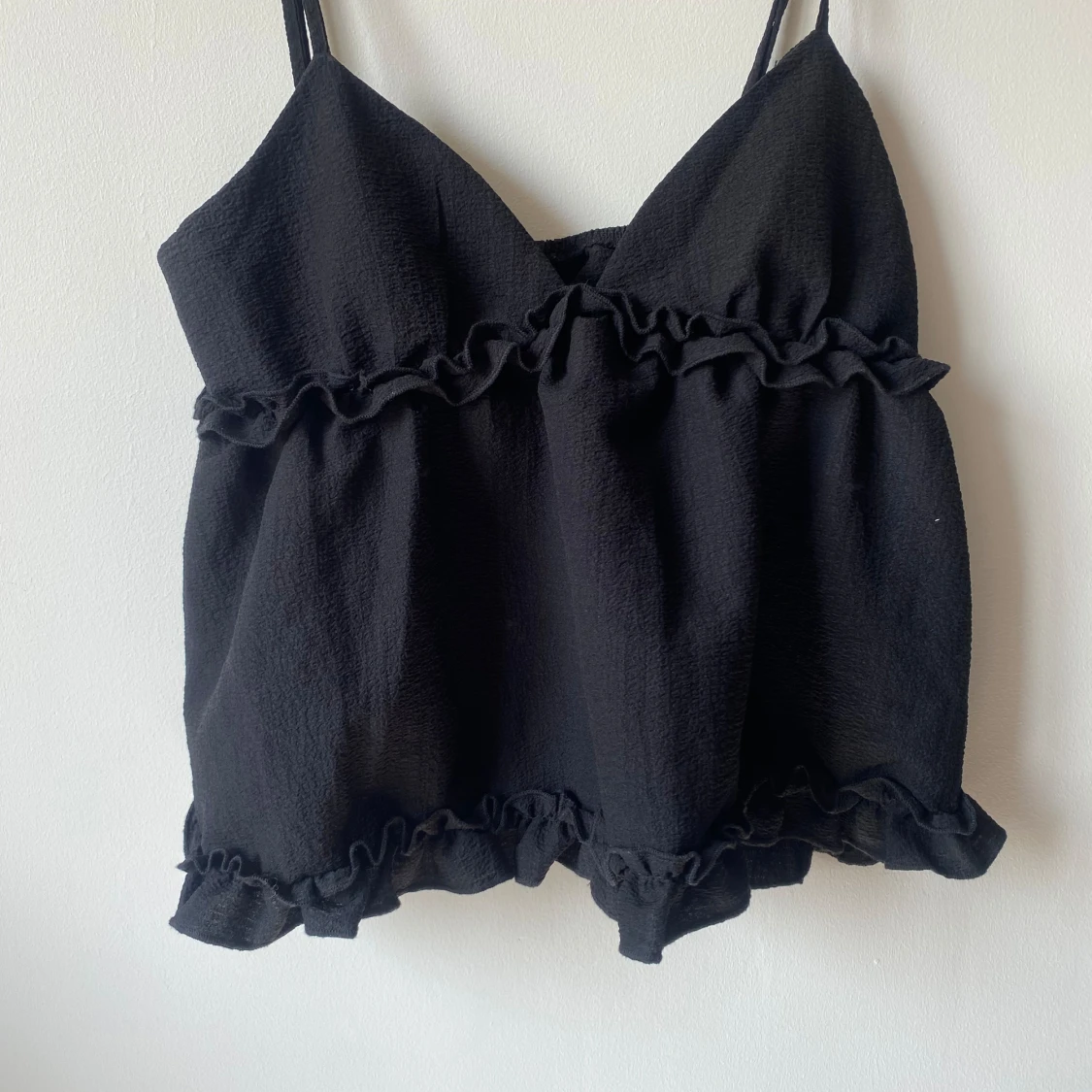Svart ärmlös topp med volanger