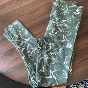 Säljer ett par gröna leggings med ett coolt vitt mönster. Perfekta för träning eller en avslappnad dag. De är superbekväma och har en snygg passform. Passar perfekt för dig som vill ha något stilrent men ändå lite annorlunda.