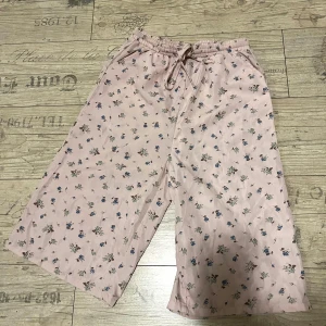 Rosa blommiga maxishorts - Rosa blommiga maxishorts som når till knänen på mig (är själv 175 cm) passar storlek xs till m, för de är stretcha i midjan. Använd 1 gång.