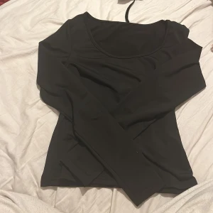 Svart långärmad topp från Shein - Säljer en stilren svart långärmad topp från Shein. Den är perfekt för både vardag och fest med sin enkla men eleganta design. Toppen är i storlek S och har en tight passform som framhäver figuren. Materialet känns mjukt och bekvämt mot huden.