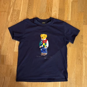 Polo ralph lauren tröja - Riktigt snygg polo tröja med teddy bear tryck. Tröjan är använd men har inga skador, vid fler frågor är det bara att skriva