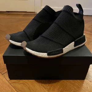 Adidas NMD CS1 Primeknit - Adidas NMD City Socks i storlek 42. Svåra att få tag på. Liten fläck på ovansidan på vänster sko (bild 4). Utöver det i bra skick.