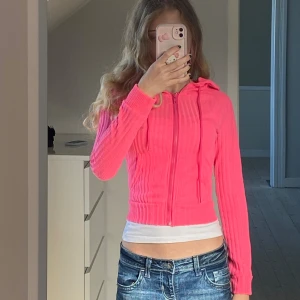 Rosa ribbad hoodie - Säljer denna rosa, tajtare hoodie som är ribbad och har dragkedja. Y2K och söt!!! Inga defekter, bara provad på, nyskick alltså. Köpt på Plick för ett tag sedan. 
