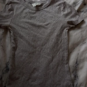 Grå T-shirt - Jag säljer en tajt, ribbad, grå tröja från H&M. Den är super fin och har dessutom skönt matrial. Har använt den 4-7gånger kanske, det har bara blivit att jag har använt andra kläder!💕