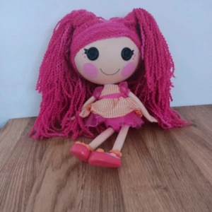 Docka med rosa hår och klänning - Söt docka med långt rosa hår och en färgglad klänning. Klänningen har en orange och vit randig topp med rosa detaljer och en volangkjol. Dockan har också rosa skor som matchar håret. Perfekt för lek och dekoration! 