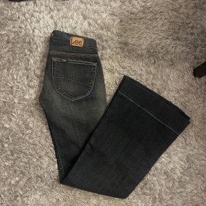 Lågmidjade Lee jeans - Lågmidjade Lee jeans i storlek 26/33 i en typ mörkblå/svart färg. Skitsnygga men för små för mig. Innerbenet är 80cm och midjan rakt över är 38cm. Gylfen är sönder men den är typ 2cm så syns inte när de är på och knäppta!