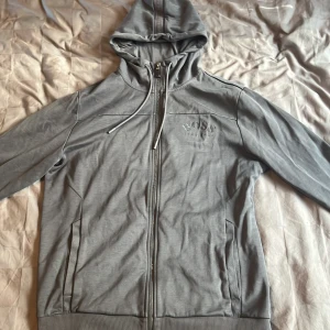 Hugo boss zip hoodie  - En grå Hugo boss hoodie i storlek L, ganska små i storleken så passar M, inte oanvänd men inga skador på den.
