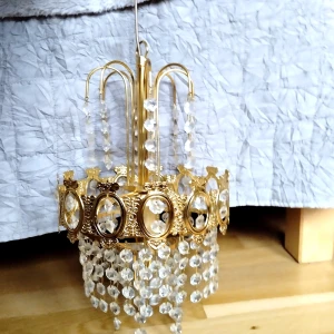 Kristallampa i guld - Säljer min älskade kristallampa som tyvärr ej har plats hos mig. Den är köpt secondhand men är som ny.Den är ca 33x20cm (ej mätt upp till kontakten.)