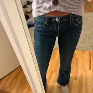 Mörkblå jeans med låg midja - Säljer ett par snygga mörkblå jeans med låg midja. De har en klassisk femficksdesign och stängs med en knapp och dragkedja. Perfekta för vardagsbruk och kan enkelt matchas med olika toppar. Storlek 152
