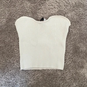 Vit tube topp - Vit ribbstickad tubetopp ifrån H&M. I storlek M (mycket liten i storleken). Använd fåtal gånger och inga defekter. Säljer pga den inte kommer till användning längre. 