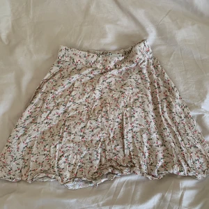 Blommig kjol - Blommig kjol i tunt tyg från NA-KD. Beige i färgen. Välanvänd men bra skick.