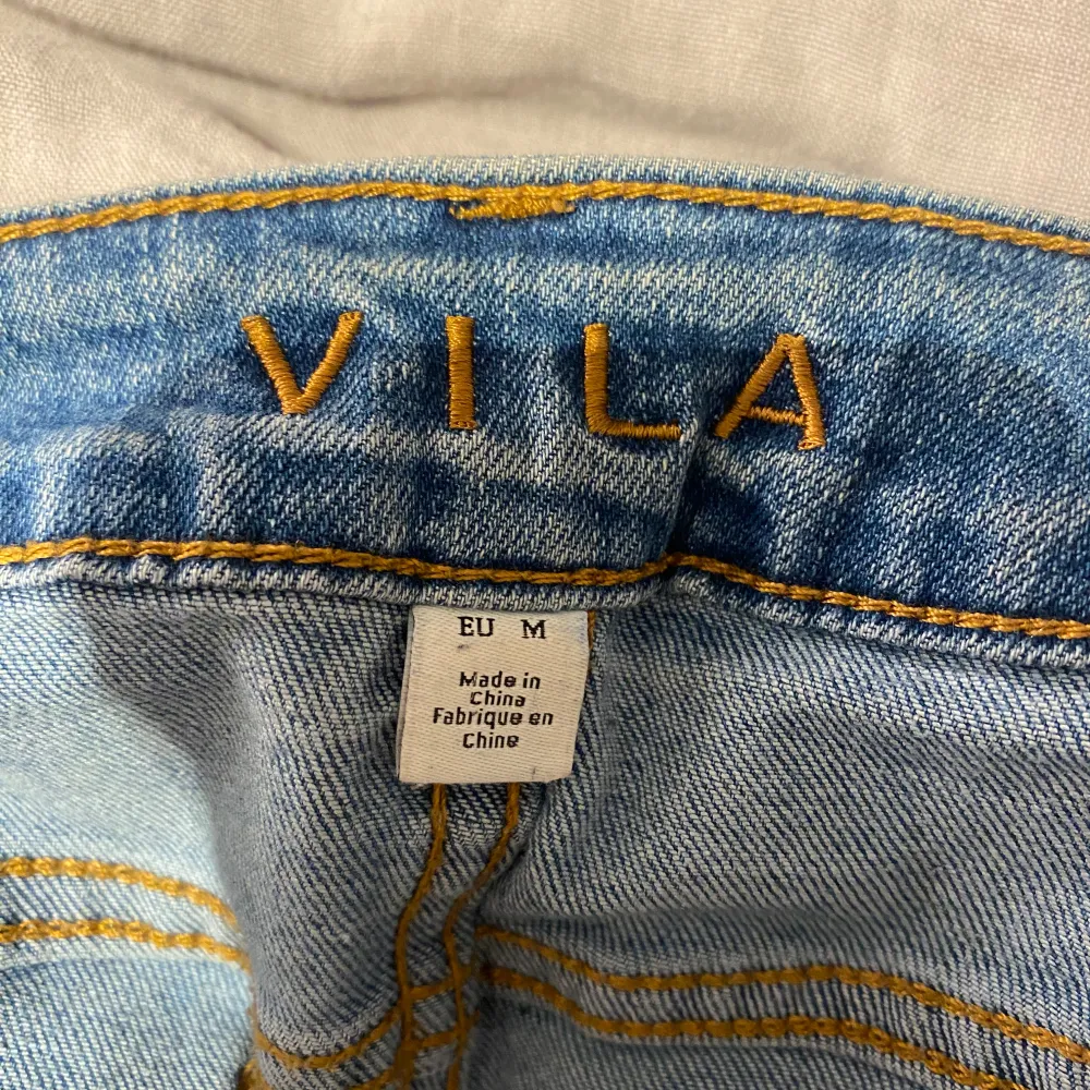 Säljer ett par blå jeans från Vila i storlek M. De har en tight passform och är i en klassisk blå färg. Tyvärr finns det en reva vid fickan som syns på bilden. . Jeans & Byxor.