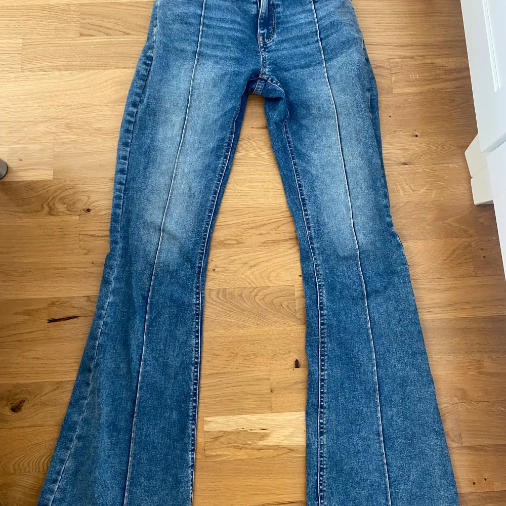 Säljer ett par snygga blå bootcut jeans från Lindex. De har en klassisk femficksdesign och är tillverkade i ett slitstarkt denimtyg. Perfekta för en avslappnad vardagslook!. Jeans & Byxor.