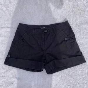 Svarta enkla shorts från H&M köpta second hand. Fram och bakfickor, coola knappar. Går att vika ner ca 8 cm till. Storlek 40, passar M. Midjemått: 41 cm. Bra skick🖤