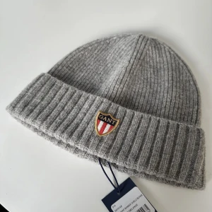 Gant **helt oanvänd mössa** - Helt oanvänd mössa med lapparna kvar.   Storlek: One Size  Märke: Gant  Lammull