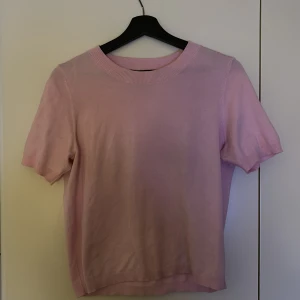 Rosa kortärmad tröja från Lindex - Säljer en söt rosa kortärmad tröja från Lindex. Perfekt för vår och sommar med sin mjuka bomullskänsla. Enkel och stilren design som passar till många olika outfits.