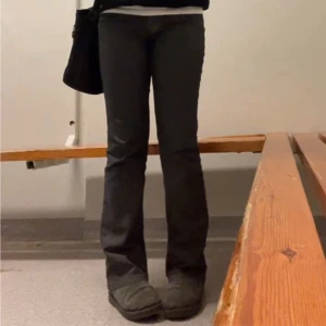 Grå/svarta vintage bootcut jeans - Snygga bootcut jeans med  dekorativa sömmar på bakfickorna. Använda men fortfarande i bra skick!