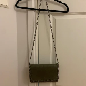 Olivgrön axelväska med kedjedetaljer - Snygg olivgrön Stella McCartney liknande väska i väldigt bra skick. 