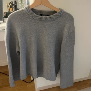 Grå stickad tröja från Gina Tricot - Mysig grå stickad tröja från Gina Tricot med rund hals och långa ärmar. Knappt använd och inga defekter. Perfekt för kyliga dagar och enkel att matcha med olika outfits. Skriv för fler bilder eller frågor💕