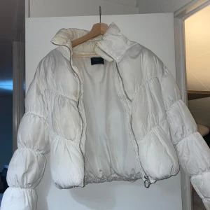 Jacka - Säljer en snygg vit pufferjacka från Bershka. Jackan har en dragkedja framtill och är perfekt för kyligare dagar. Den har en luftig passform och långa ärmar, vilket gör den både bekväm och trendig. Den är använd och har fläckar och defekter därav priset. Den går att tvätta! Passar även xs och s så liten i storleken 