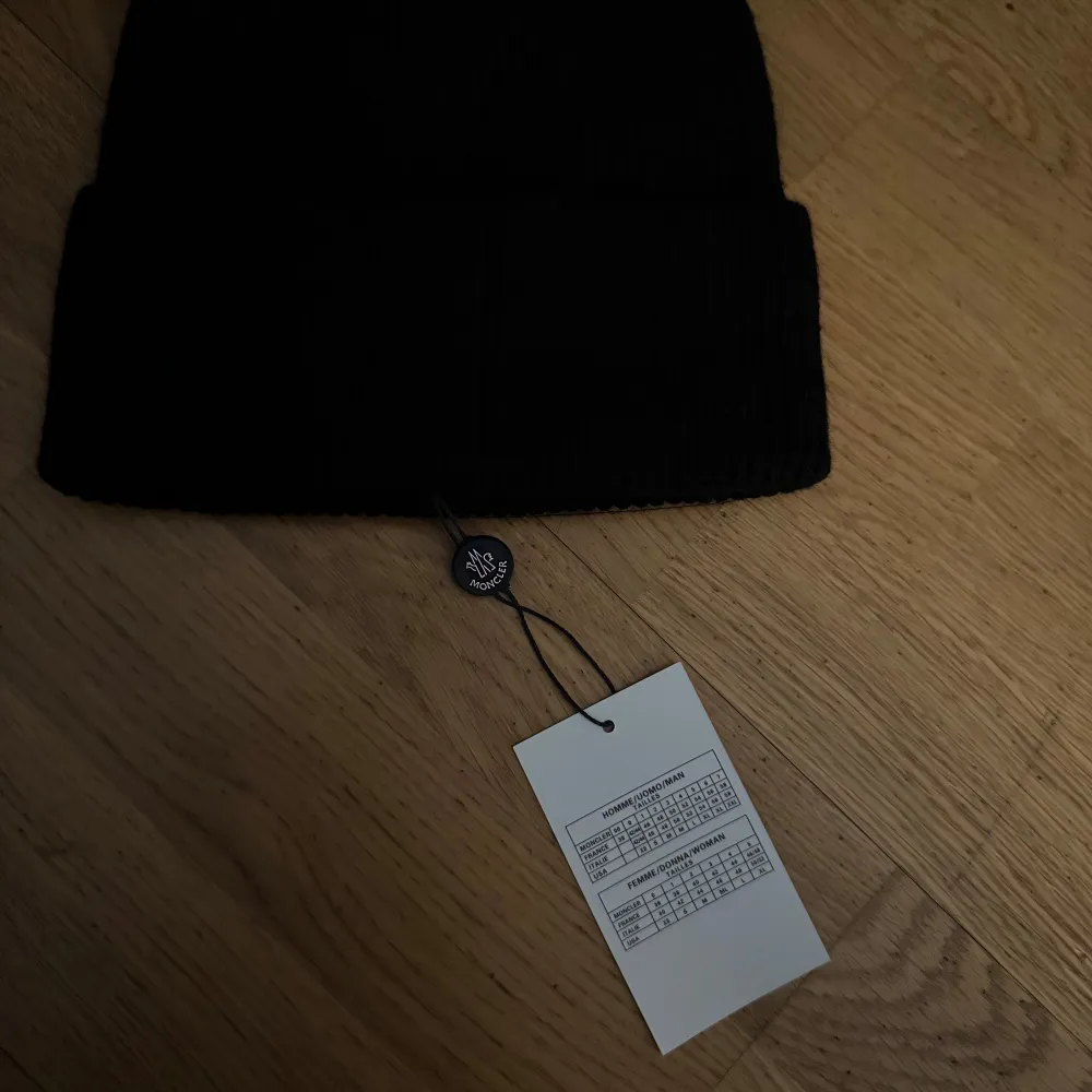 Snygg svart mössa från Moncler med broderad logotyp framtill. Perfekt för att hålla värmen under kyliga dagar. Stilren design som passar till det mesta.. Asusteet.