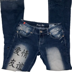 Mörkblå Crazy Age jeans  - Sjuka mörkblåa bootcut jeans från Crazy Age med unikt tryck i svart på både fram- och baksida. Älskar de men behöver tyvärr sälja för att de inte passar mig 