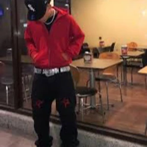 Röd y2k huvtröja med dragkedja - Säljer en röd huvtröja med dragkedja och fickor framtill. Tröjan har en justerbar huva med snören och långa ärmar. Perfekt för en avslappnad stil.