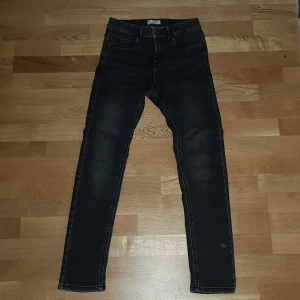 Svarta jeansbyxor från Lindex - Snygga svarta jeansbyxor från Lindex i storlek EUR 158. Byxorna har en klassisk design med fem fickor och en bekväm passform. Perfekta för både vardag och speciella tillfällen.