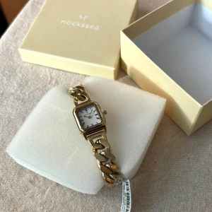 Ny guld klocka, Mockberg GRACE - Helt ny guld klocka från Mockberg i modellen Grace. Aldrig kommit till användning tyvärr, så oanvänd, inplastad och med original förpackning. Kvitto finns om så önskas.   Originalpris 1899 kr 💌