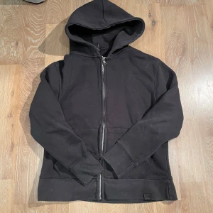Svart hoodie från Pull&Bear - Säljer en stilren svart hoodie från Pull&Bear med dragkedja framtill. Perfekt för en avslappnad look. Den har en klassisk design med huva och långa ärmar. Tröjan är XS men passar även S. 160-170