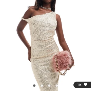 Glittrig oneshoulder klänning - Snygg glittrig oneshoulder klänning i ljus nyans. Perfekt för festliga tillfällen med sin figurnära passform och eleganta design. Endast provats - aldrig använd. 