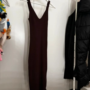 Brun ribbad klänning - Snygg brun ribbad klänning med smala axelband och en figurnära passform. Perfekt för en stilren look.