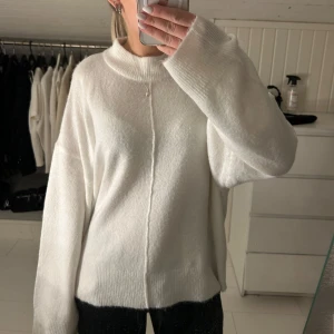 Vit stickad tröja - Mysig vit stickad tröja med en avslappnad passform med en fin detalj. Perfekt för kyligare dagar och enkel att matcha med olika outfits då den passar till allt. Aldrig använd!!! I storlek L men skulle säga mer S/M, då den är mer over, size i modellen och jag har vanligt vis s/m, Pris 250kr💌