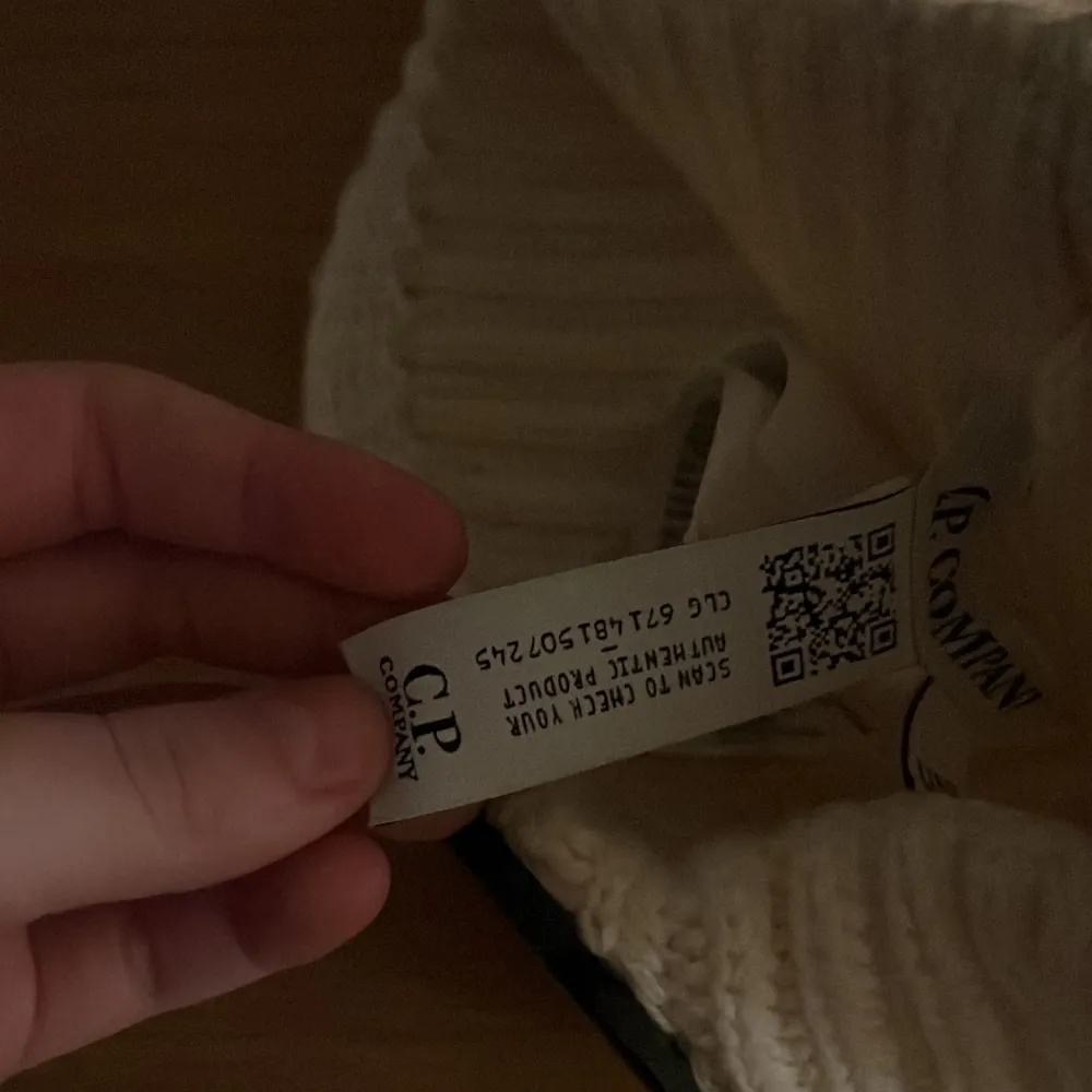 Snygg vit ribbad mössa från C.P. Company med unika glasögondetaljer framtill. Perfekt för att ge din outfit en cool touch.. Asusteet.