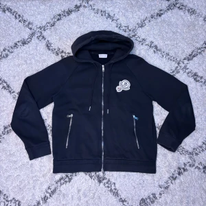Moncler Hoodie - Väldigt snygg Moncler hoodie. Färgen är väldigt mörkblå ser nästan ut som svart. Skicket är mycket bra och det finns inga flaws. Passar medium