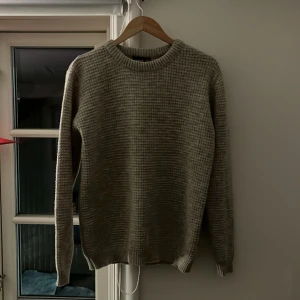 Beige stickad tröja - Säljer en mysig beige stickad tröja med rund hals och långa ärmar. Perfekt för kyliga dagar och enkel att matcha med olika outfits.