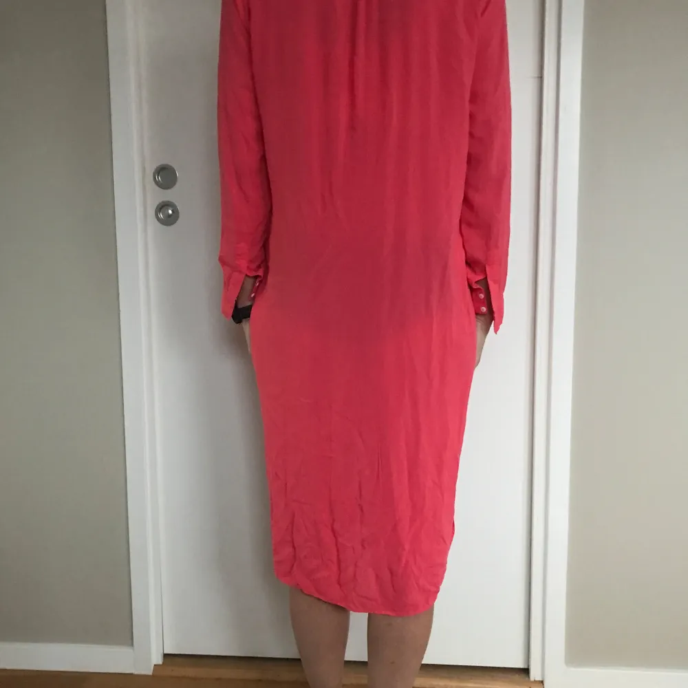Korallfärgad klänning/kaftan med ficka på vänster sida och är något längre baktill än framtill. Färgen inte lika intensiv i verkligen. Zara Stl S. 100% viscose helt underbar kvalitet, såå mjuk o skön. Använd en gång, nytvättad är i nyskick. Säljer även matchande sandaler H&M Stl 38, se mina övriga annonser.. Mekot.