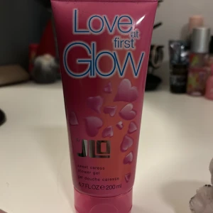 Love at First Glow duschgel - Love at First Glow duschgel från JLO i en rosa tub med hjärtmönster. Innehåller 200 ml och har en söt doft som ger en fräsch känsla. Perfekt för en uppfriskande duschupplevelse.💗