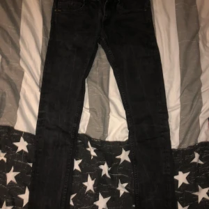 Svarta jeansbyxor - Snygga svarta jeansbyxor med en tight passform. Perfekta för en stilren look. De har klassisk design med dragkedja och knappar.