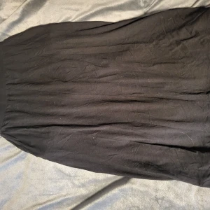 Svart kjol från Rainbow - Snygg svart kjol från Rainbow med en klassisk design. Kjolen har en bekväm passform och är perfekt för olika tillfällen. Den är gjord i ett mjukt material som ger en fin fall.